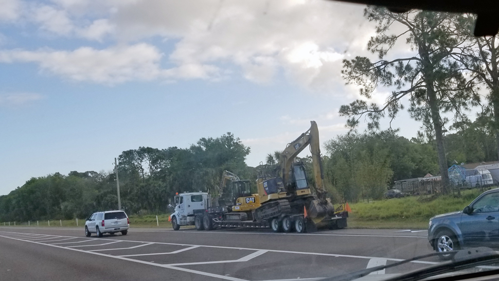 A truck carrying a backhoe struck the State Road 528 overpass at Interstate 95 in Brevard County on Friday, March 29, 2019, according to the Florida Highway Patrol. (Photo courtesy of Steve McGuffey, viewer)